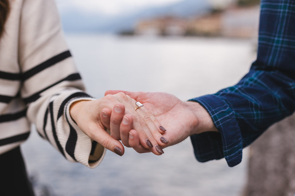 new fiance's holding hand with italy in background showcasing new engagement ring.