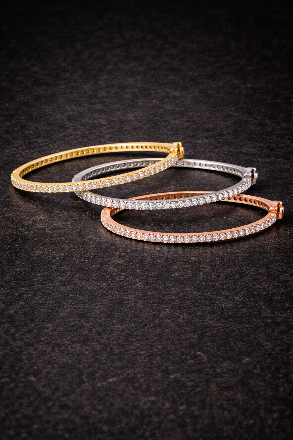 3 diamond bracelets laying on a top slightly stacked on top of each other